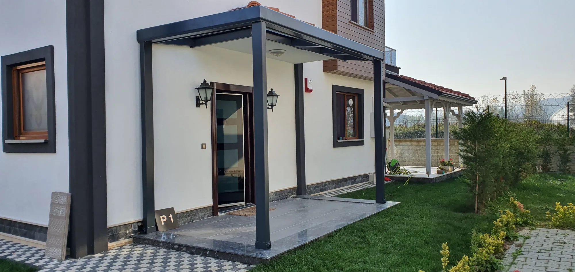 Ev girişinde antrasit cam sundurma