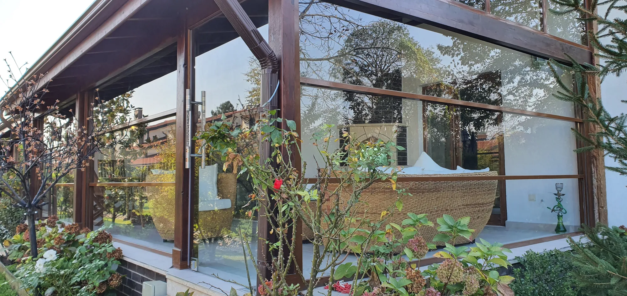 Çiçekli bahçede cam veranda